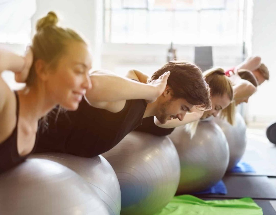 Groep mensen met gymnastische oefeningen met opblaasbare ballen in een sportschool
